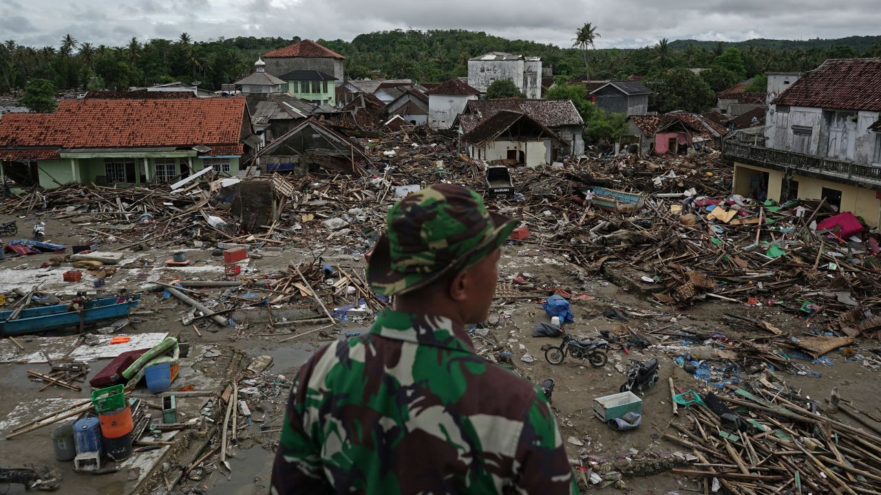 An Indonesian soldier looks at damaged houses and debris in Sumur, Indonesia, on Tuesday, December 25.