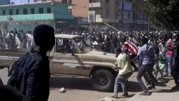 In this Sunday, Dec. 23, 2018 handout photo provided by a Sudanese activist, people chant slogans and attack a national security vehicle during a protest, in Kordofan, Sudan. The protest on Sunday was the latest in a series of anti-government protests across Sudan, initially sparked by rising prices and shortages. (Sudanese Activist via AP)