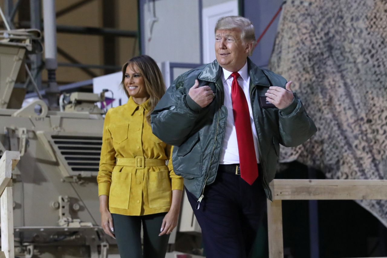 The Trumps walk onstage to speak at a hangar rally during their surprise visit.