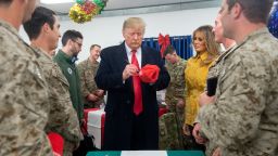 US President Donald Trump signs a hat as first lady Melania Trump looks on as they greet members of the US military during an unannounced trip to Al Asad Air Base in Iraq on December 26, 2018. (Photo by SAUL LOEB / AFP) 