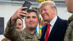 US President Donald Trump takes a photo as he greets members of the US military during an unannounced trip to Al Asad Air Base in Iraq on December 26, 2018. (Photo by SAUL LOEB / AFP)  