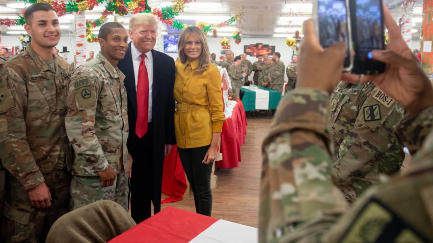 US President Donald Trump and First Lady Melania Trump take photos with members of the US military during an unannounced trip to Al Asad Air Base in Iraq on December 26, 2018. - President Donald Trump arrived in Iraq on his first visit to US troops deployed in a war zone since his election two years ago (Photo by SAUL LOEB / AFP) (Photo credit should read SAUL LOEB/AFP/Getty Images)