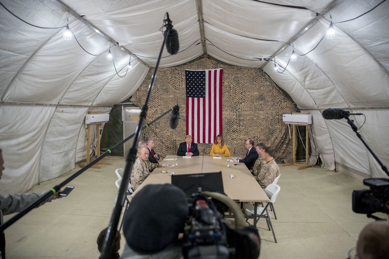 President Trump, accompanied by National Security Adviser John Bolton, third from left, first lady Melania Trump, fourth from right, US Ambassador to Iraq Doug Silliman, third from right, and senior military leadership, speaks to members of the media during his surprise visit to Iraq.