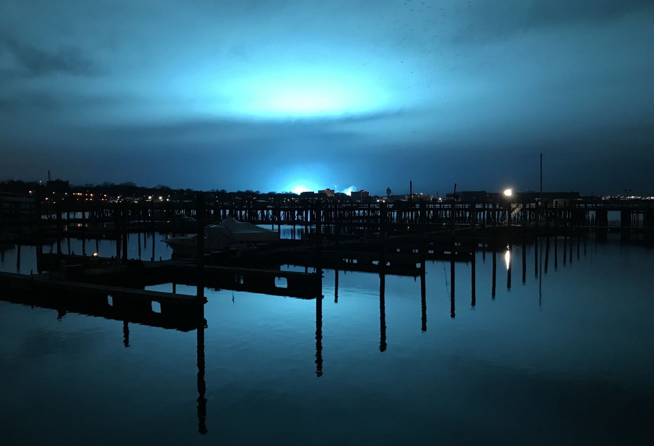 Blue light illuminates the night sky after the incident. 
