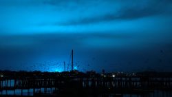 NEW YORK, USA - DECEMBER 27: Birds fly over a pier as a blue light illuminates the night sky after a transformer explosion at Queens Borough in New York, United States on December 27, 2018. (Photo by Simin Liu/Anadolu Agency/Getty Images)