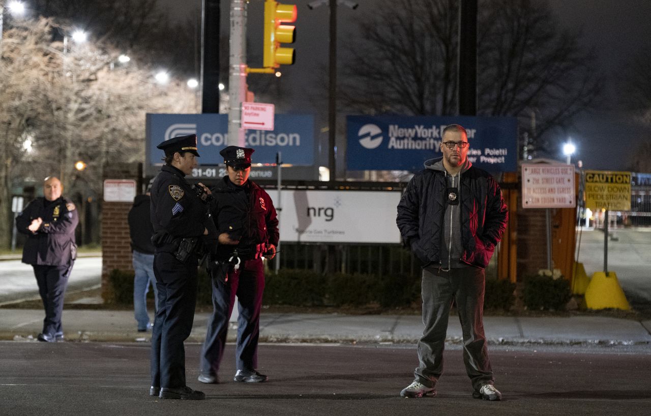 Law enforcement personnel stand in front of a Con Edison facility in Queens.