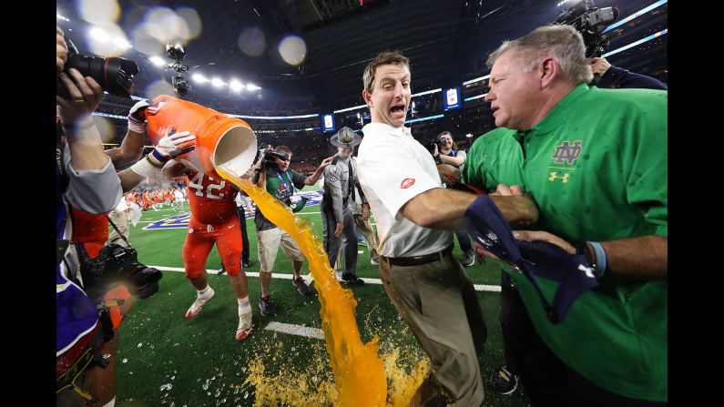 Clemson Tigers head coach Dabo Swinney is doused with Gatorade while shaking hands with Notre Dame Fighting Irish head coach Brian Kelly at the end of the Cotton Bowl on December 29 in Arlington, Texas. 