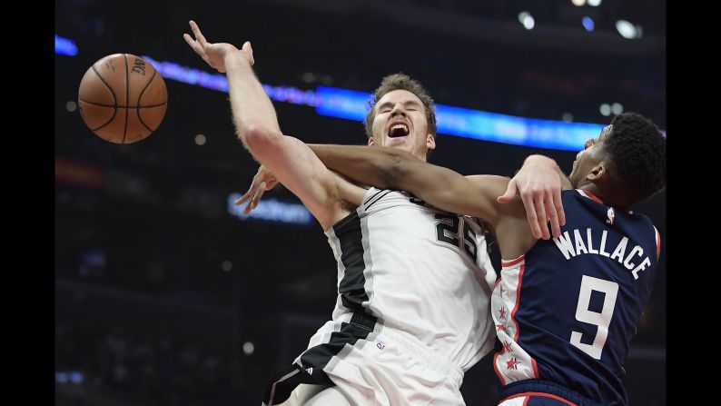 San Antonio Spurs center Jakob Poeltl, left, tries to shoot as Los Angeles Clippers guard Tyrone Wallace defends during the first half of a game on December 29 in Los Angeles. 
