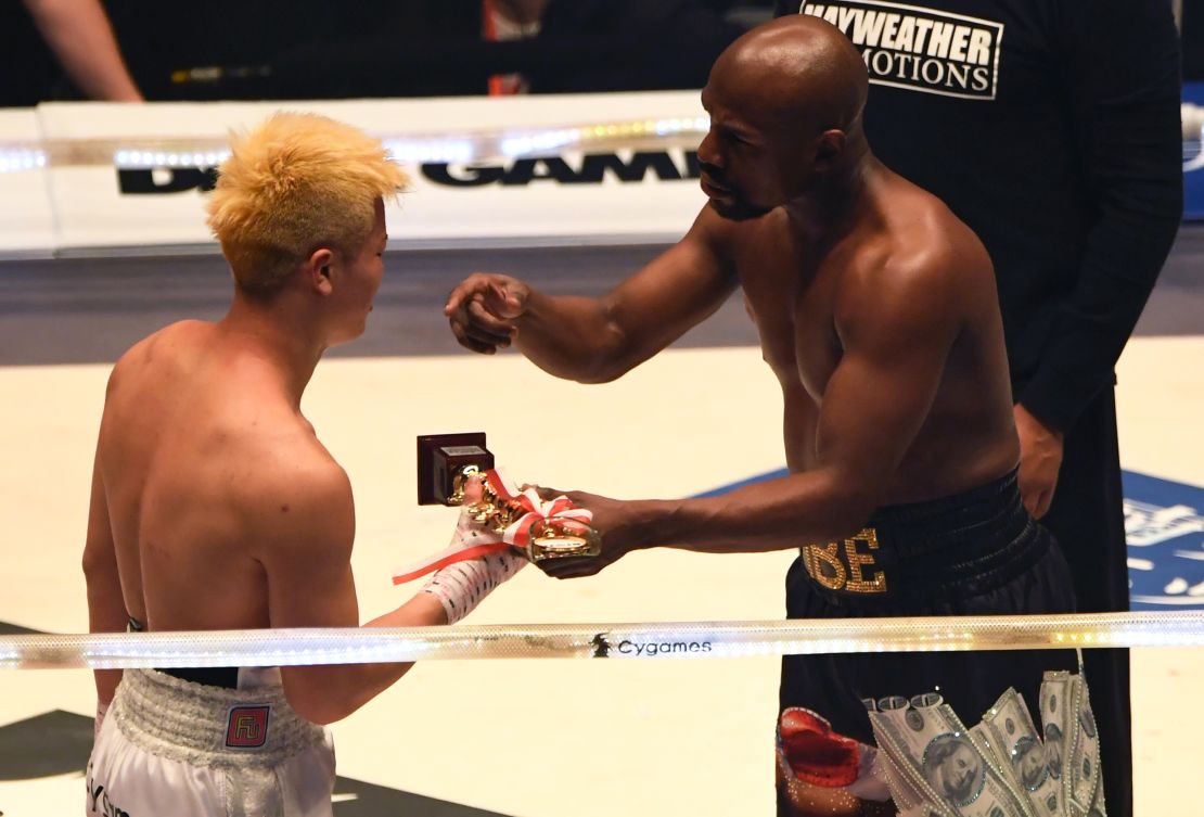 Mayweather sportingly offers his trophy to his kickboxing opponent Tenshin Nasukawa of Japan after their exhibition bout. 