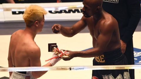 Mayweather sportingly offers his trophy to his kickboxing opponent Tenshin Nasukawa of Japan after their exhibition bout.