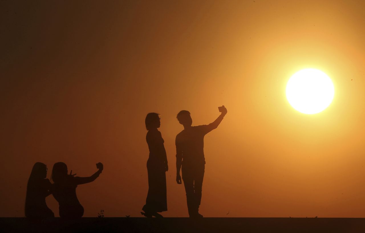 People take selfies during the last sunset of the year in Myanmar.