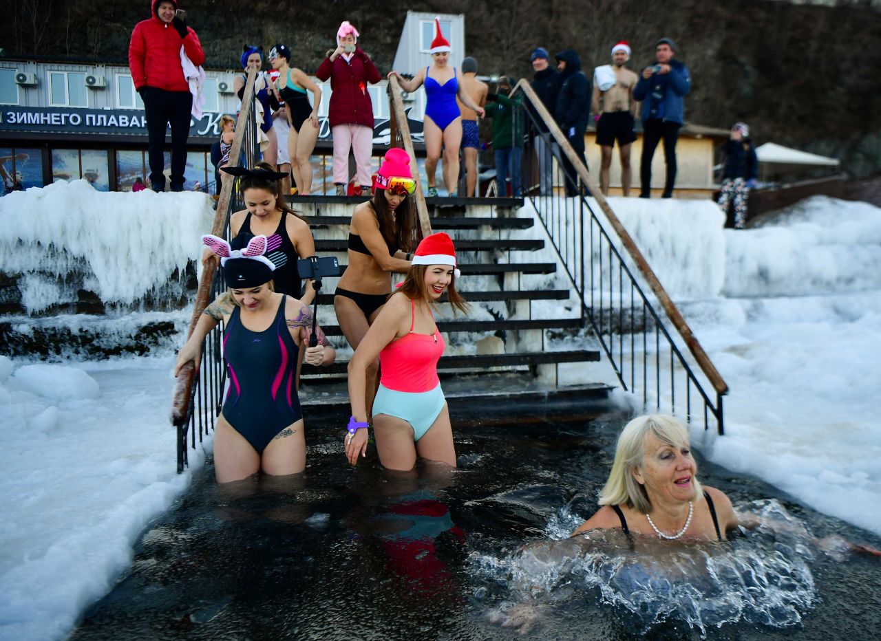 Members of the Kosatka DV winter-swimming club see out the old year in an ice hole in Russia.