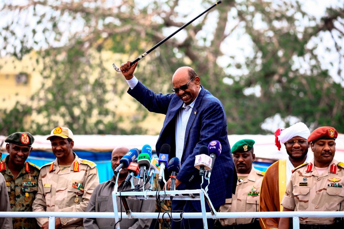Omar al-Bashir waves his cane while giving a speech in Nyala, the capital of South Darfur province, on September 21, 2017.