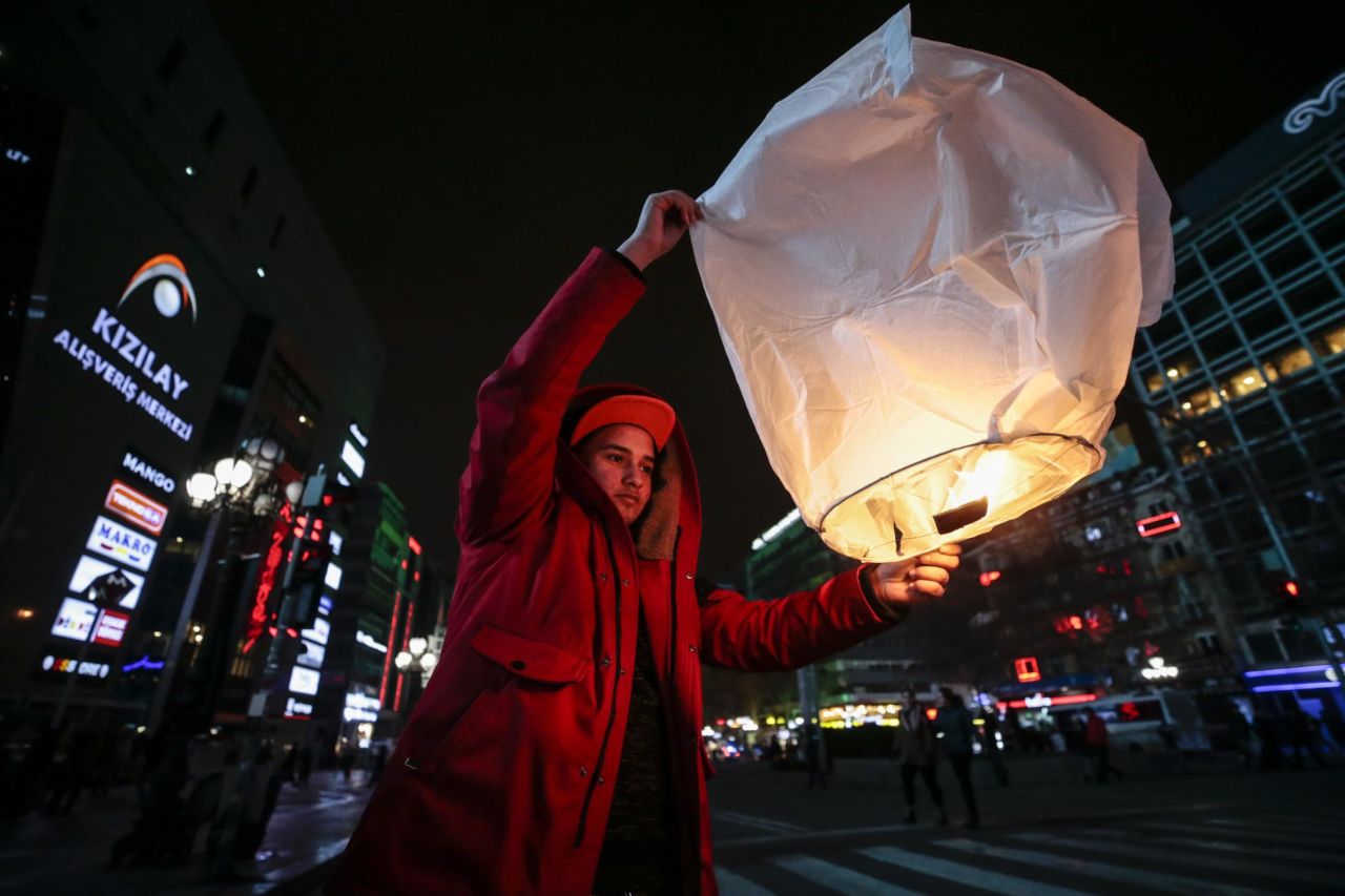 A boy releases a balloon carrying his personal wishes as people gather at Kizilay Square in Ankara, Turkey.