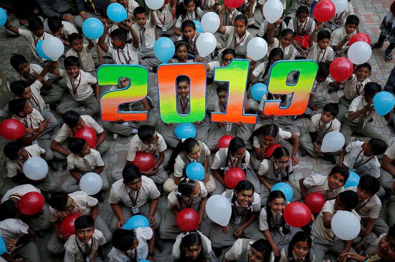 Schoolchildren hold balloons during New Year's celebrations at their school in Ahmedabad, India.
