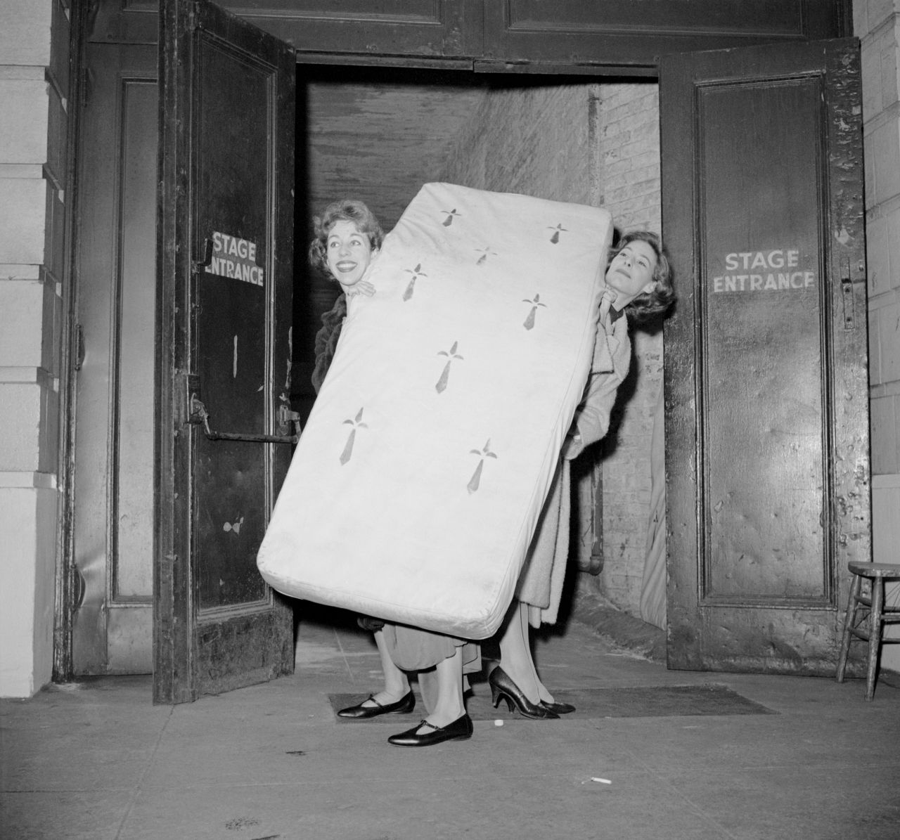 Burnett, left, and Mary Rodgers move a prop mattress through the stage door of the Alvin Theatre in New York in 1959. Burnett's first Broadway play was the musical "Once Upon a Mattress," and Rodgers wrote the score. Burnett earned a Tony Award nomination for her work on the play.