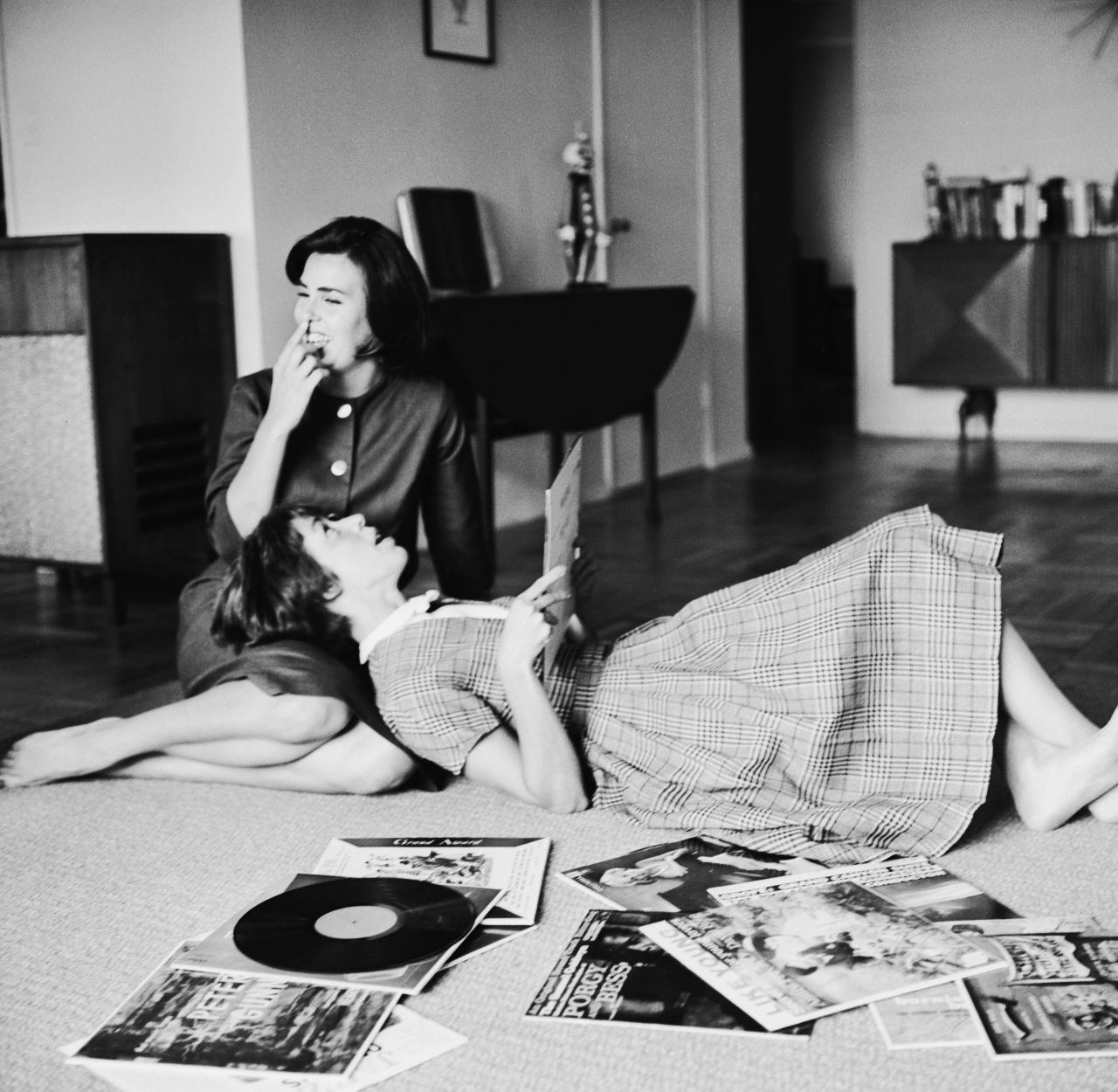 Burnett and her sister, Chrissie, listen to records on the floor of Burnett's apartment in 1959.