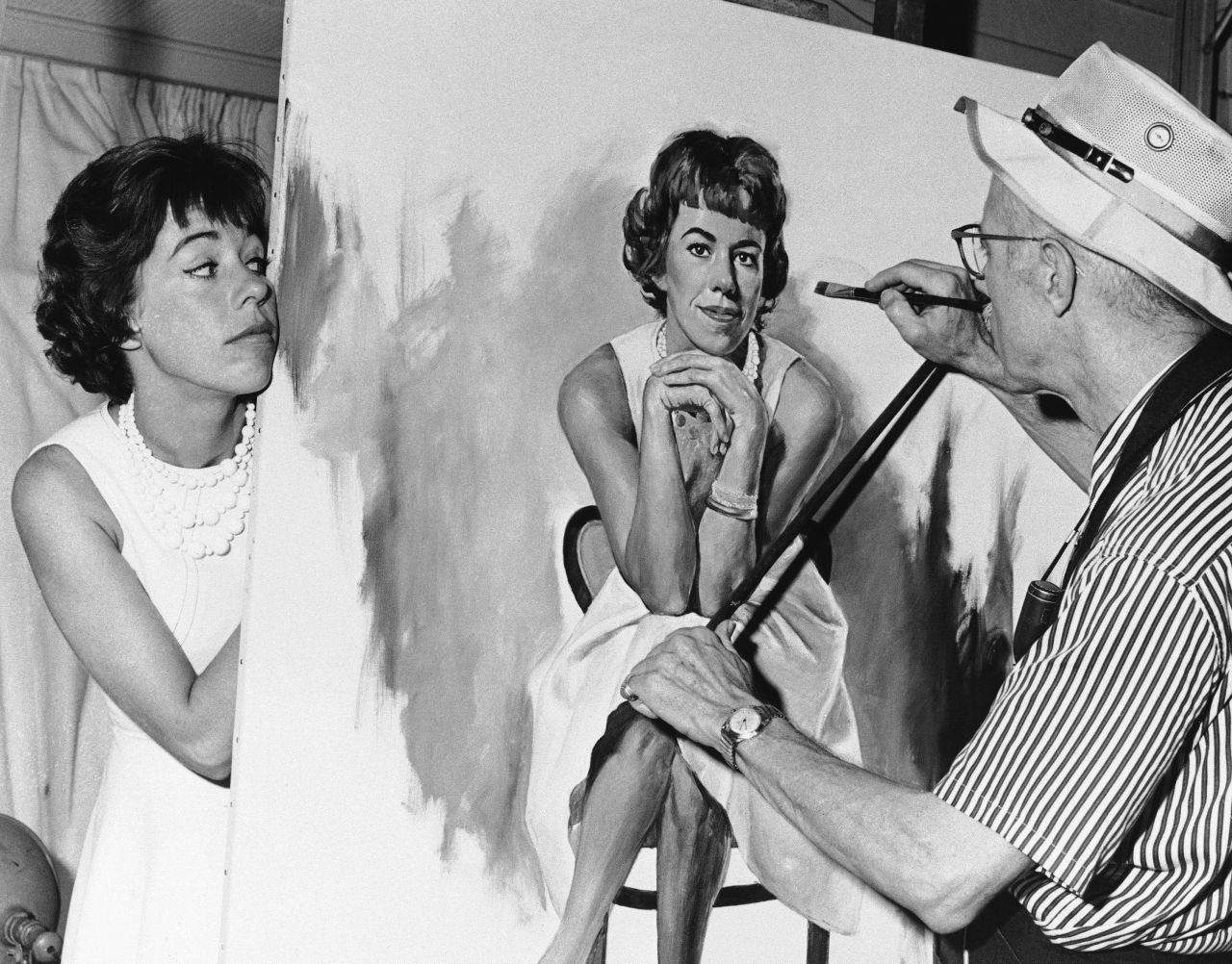 Burnett peeks at a portrait of herself that was being painted by artist Dmitri Vails in 1963.