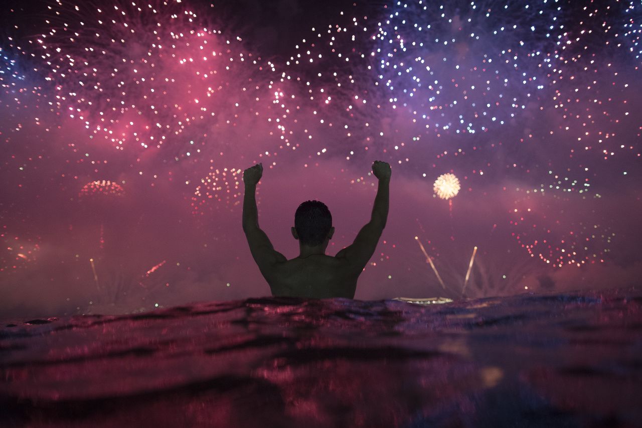 A man watches the fireworks at Copacabana Beach in Rio de Janeiro.