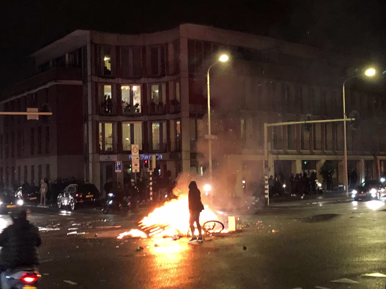 A person walks in front of a fire in The Hague, Netherlands, during a demonstration against the Dutch government's coronavirus measures on November 20.