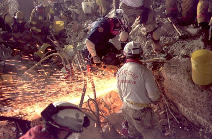 Rescue workers cut through the building's rubble.