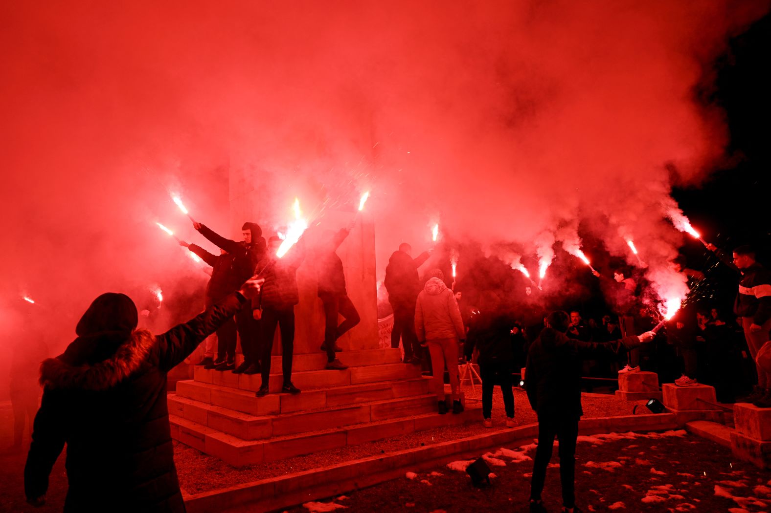 People in Cetinje, Montenegro, hold flares Sunday, January 5, during a rally that was held to remember the victims of a <a href="index.php?page=&url=https%3A%2F%2Fwww.cnn.com%2F2025%2F01%2F01%2Fworld%2Fmontenegro-shooting-new-years-day-intl%2Findex.html">mass shooting</a> on January 1. Twelve people were killed in the shooting, and the attacker died from self-inflicted injuries, authorities said.