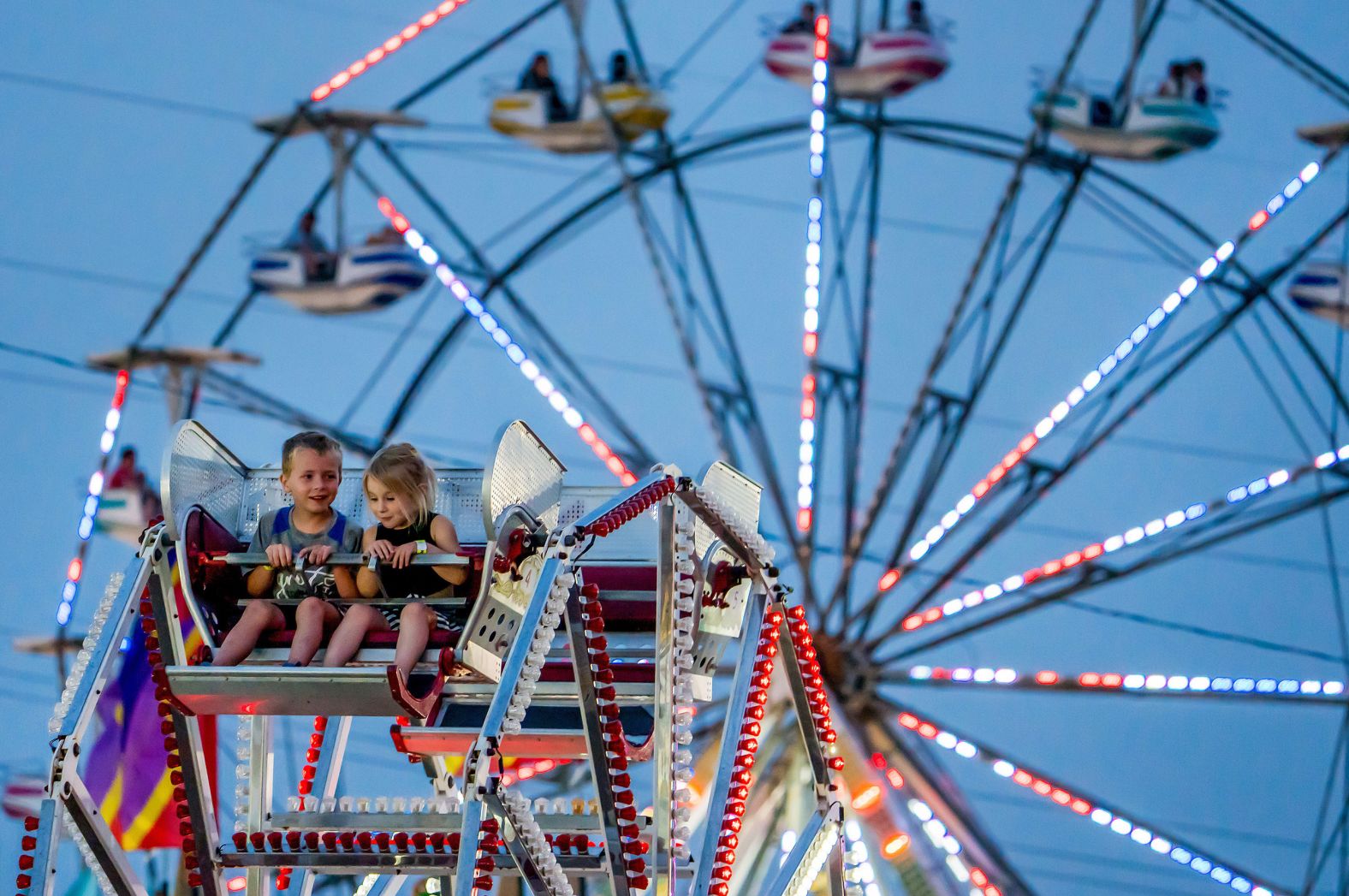 Young friends Elliott Clark and Gwen Pfeifer ride a mini Ferris wheel at the Good Neighbor Days festival in Washington, DC, on Friday, May 30.
