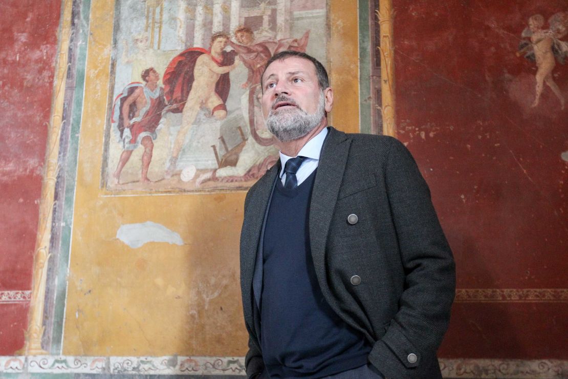 Massimo Osanna poses in front of a fresco in the Lucrezio Frontone House in Pompeii. 