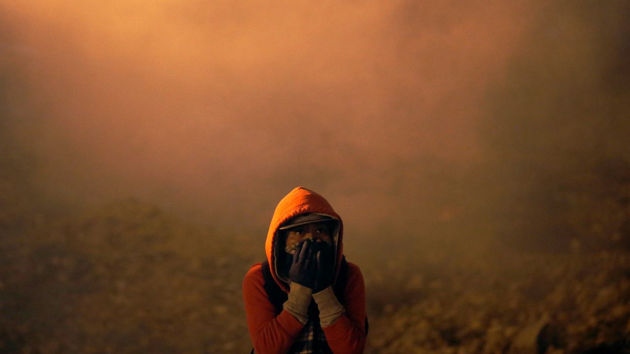 A migrant, part of a caravan of thousands from Central America trying to reach the United States, covers his face after U.S. Customs and Border Protection (CBP) throw tear gas to the Mexican side of the fence as they prepared to cross it illegally, in Tijuana, Mexico, January 1, 2019.   REUTERS/Mohammed Salem