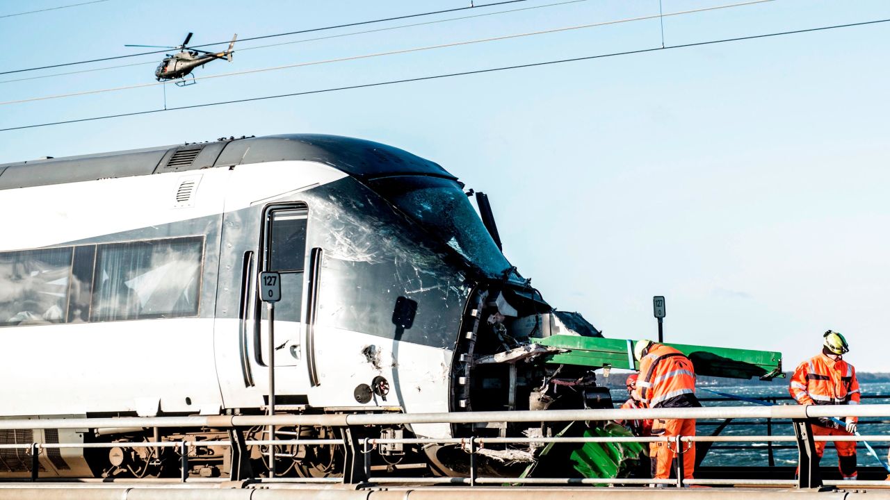 TOPSHOT - Men work at the accident site next to a passenger train standing on the rails in Nyberg, Denmark, after the Great Belt Bridge was closed following a railway accident on January 2, 2019. - Six people were killed in a train accident on a bridge connecting two islands in Denmark, rail operator DSB said. The accident occurred on the Great Belt Bridge connecting the islands of Zealand, where Copenhagen is located, and Funen. (Photo by Tim K. Jensen / Ritzau Scanpix / AFP) / Denmark OUT        (Photo credit should read TIM K. JENSEN/AFP/Getty Images)