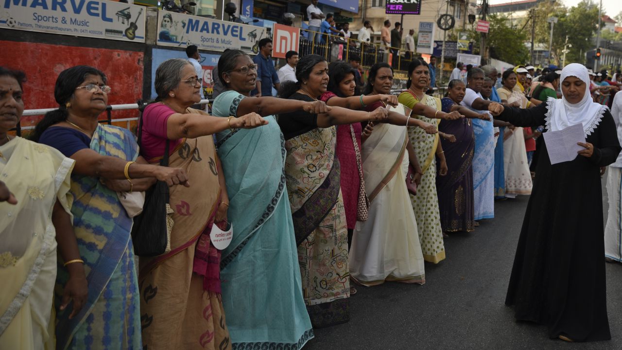 Women raise their hands to take a pledge to fight gender discrimination as they form part of a hundreds kilometer long "women's wall."