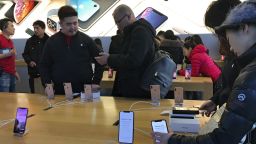 People buy latest iPhone while others try out its latest model at an Apple Store in Beijing, Tuesday, Dec. 11, 2018. China's economy czar and the U.S. Treasury secretary discussed plans for talks on a tariff battle, the government said Tuesday, indicating negotiations are going ahead despite tension over the arrest of a Chinese tech executive. (AP Photo/Andy Wong)