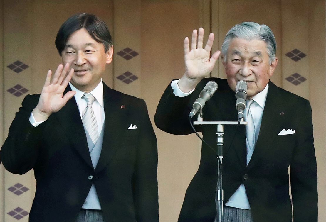 Japan's Emperor Akihito (R) and Crown Prince Naruhito (L) wave to the crowd during the New Year's greeting ceremony at the Imperial Palace in Tokyo on January 2, 2019.