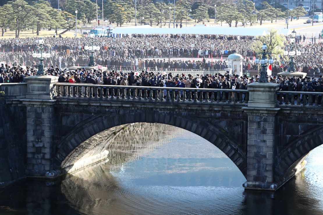 People walk along on a bridge leading to the Imperial Palace to attend Akihito's last New Year greeting ceremony in Tokyo.