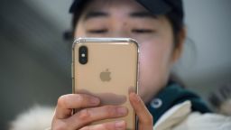 A woman uses an Apple iPhone at a shopping mall in Beijing on January 3, 2019.