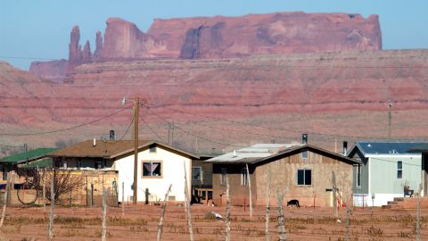 Houses are backed by sandstone cliffs on the Navajo reservation in Arizona.