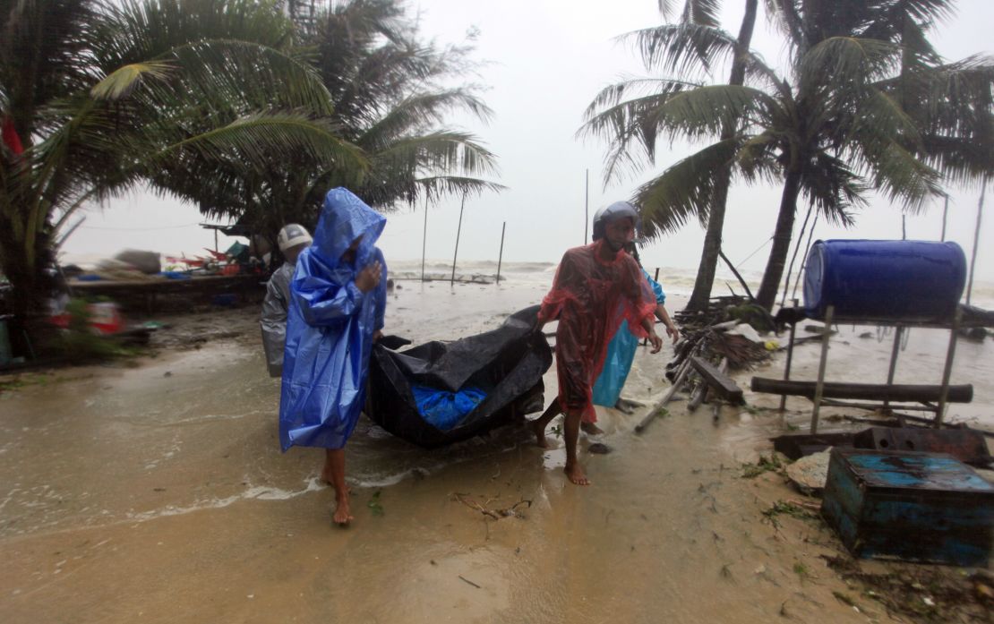 Locals clear the shoreline Friday in preparation for the approaching storm in Pak Phanang, in the southern province of Nakhon Si Thammarat.