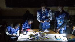 Electoral commission agents count votes during an electricity cut while watched by observers at Kiwele college in Lubumbashi on December 30, 2018.