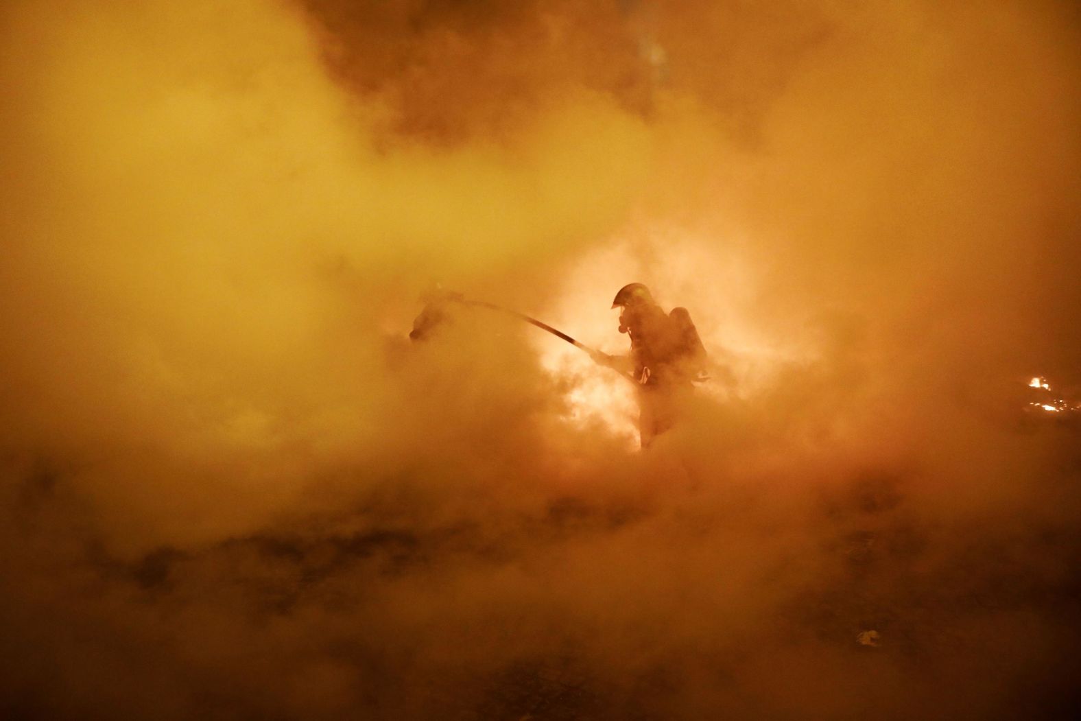 A firefighter tries to extinguish a burning car in a street in Paris on January 5.