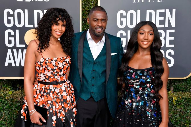 Sabrina Dhowre, Idris Elba, and Isan Elba at the 76th Golden Globe Awards during the red carpet arrivals. Idris wore a three-piece green suit by Ozwald Boateng.  