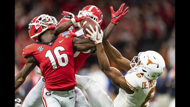 Texas wide receiver Devin Duvernay, right, competes for a ball with two Georgia defensive backs during the Sugar Bowl on Tuesday, January 1. Texas won the game 28-21.