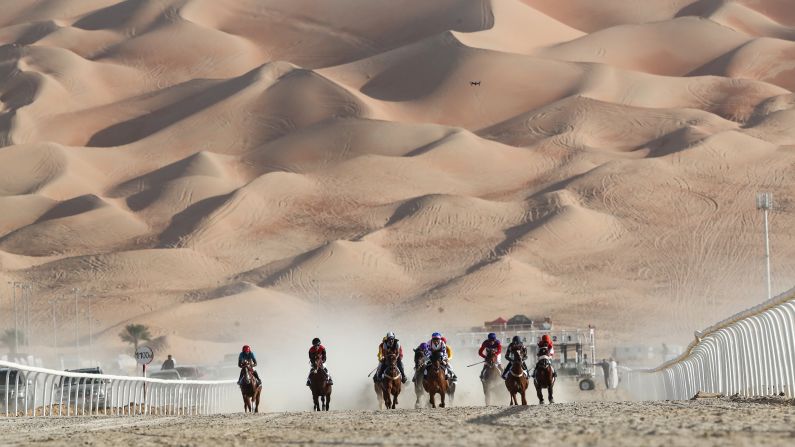 Horses race in the United Arab Emirates' Liwa desert during the Moreeb Dune Festival on Tuesday, January 1.