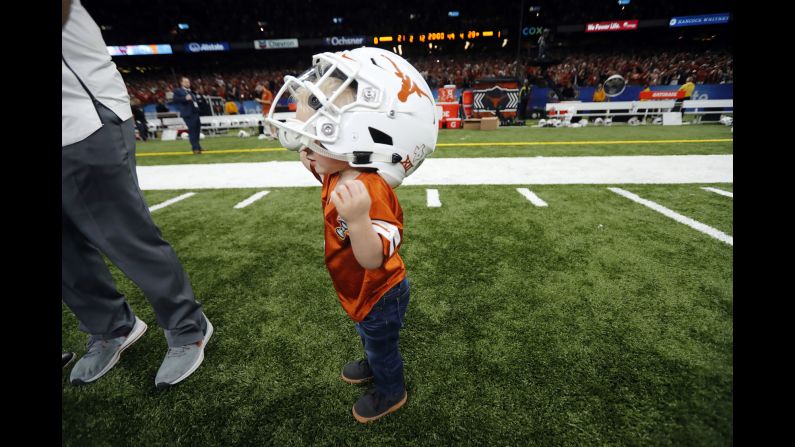 Beau Rutherford, the 1-year-old son of Texas equipment manager Matt Rutherford, dons a Texas helmet after the Sugar Bowl on Tuesday, January 1.