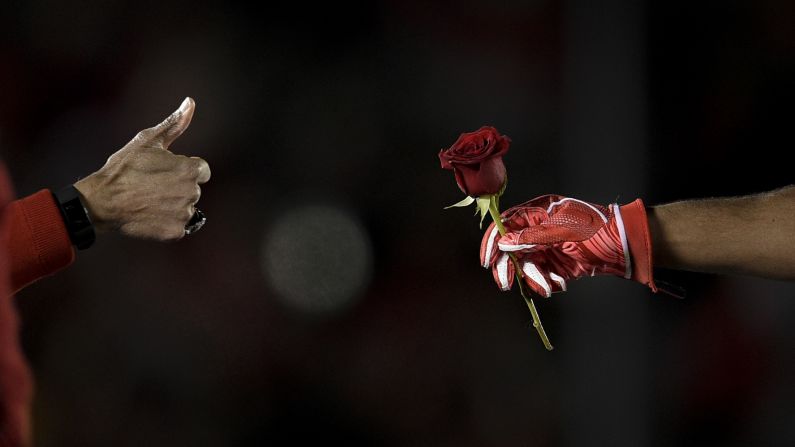 Tournament of Roses President Gerald Freeny, left, congratulates Ohio State linebacker Wyatt Davis after handing him a rose on Tuesday, January 1. The Buckeyes had just defeated Washington in the Rose Bowl 28-23.