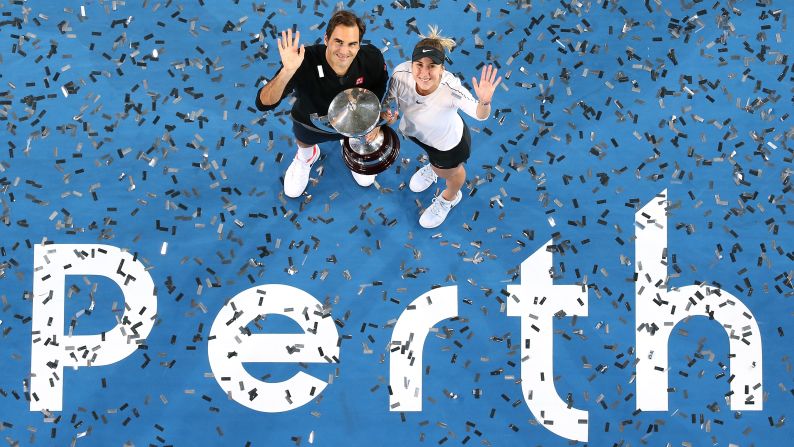 Swiss tennis players Roger Federer and Belinda Bencic pose with the Hopman Cup after winning the team tournament in Perth, Australia, on Saturday, January 5.