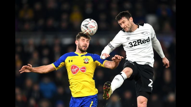 Southampton's Jack Stephens, left, wins a header with Derby County's David Nugent during an FA Cup match in Derby, England, on Saturday, January 5. The match ended 2-2.