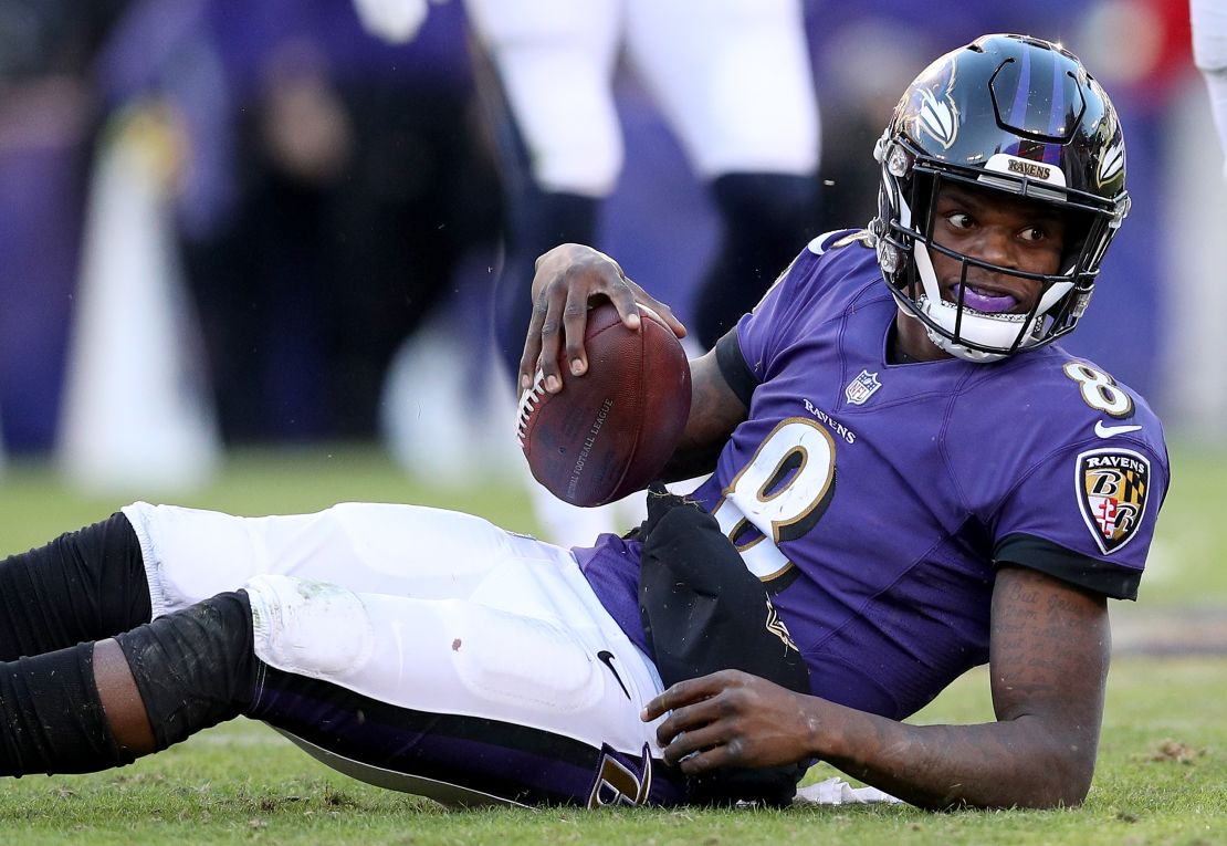 Lamar Jackson of the Baltimore Ravens looks on from the ground after being tackled.