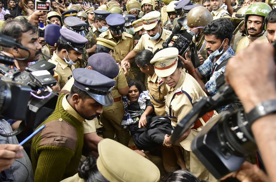 Indian police protect a female Hindu devotee after her entry to Sabarimala temple was blocked by hardline activists, December 24, 2018. 