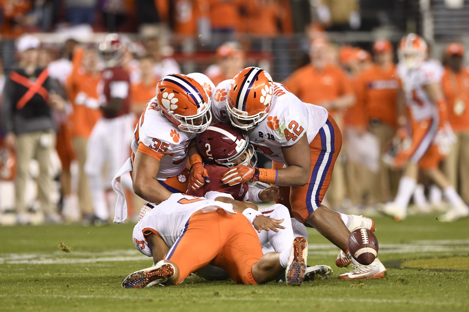 Clemson defenders swarm Alabama quarterback Jalen Hurts late in the game.