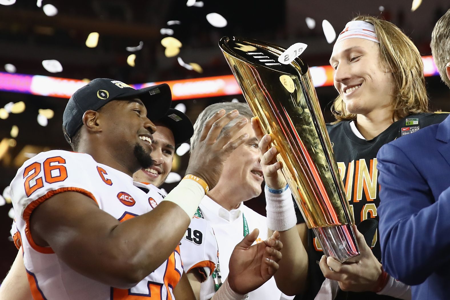 Adam Choice, left, and Trevor Lawrence celebrate with the national championship trophy.